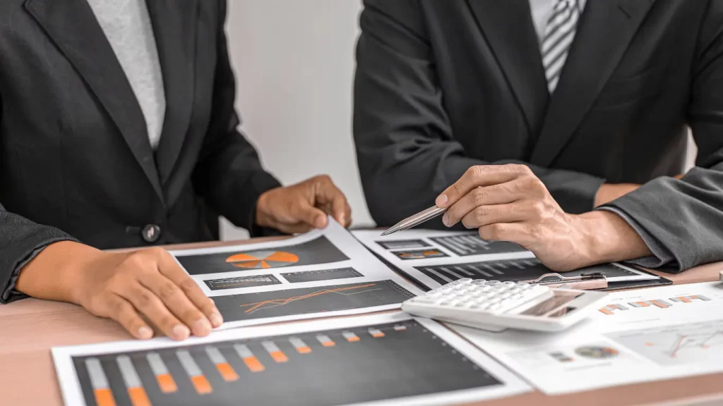 Business professionals reviewing financial reports and investment charts during a commercial real estate investment analysis.
